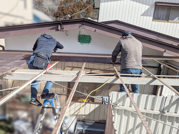便利屋サンキュー仙台本店の車庫の波板屋根を作業員2名で張り替え作業中の様子
